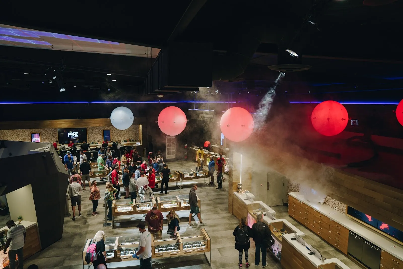 Shoppers on the floor under hanging red and white spheres