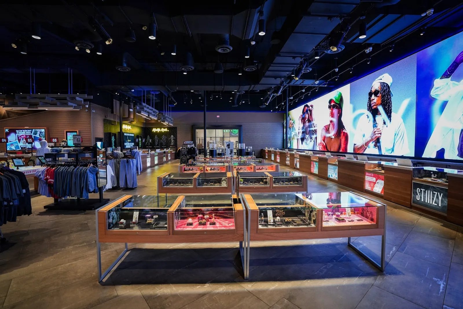 The sales floor: lit glass showcases and a wall-sized video screen