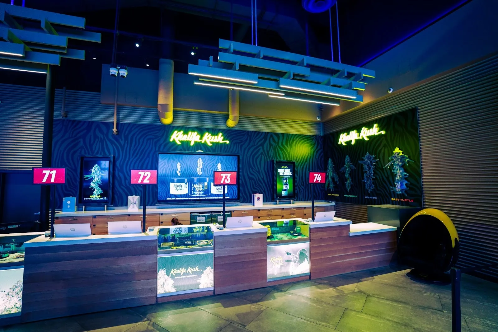 The Khalifa Kush counters on the Planet 13 Las Vegas floor, lit in green neon