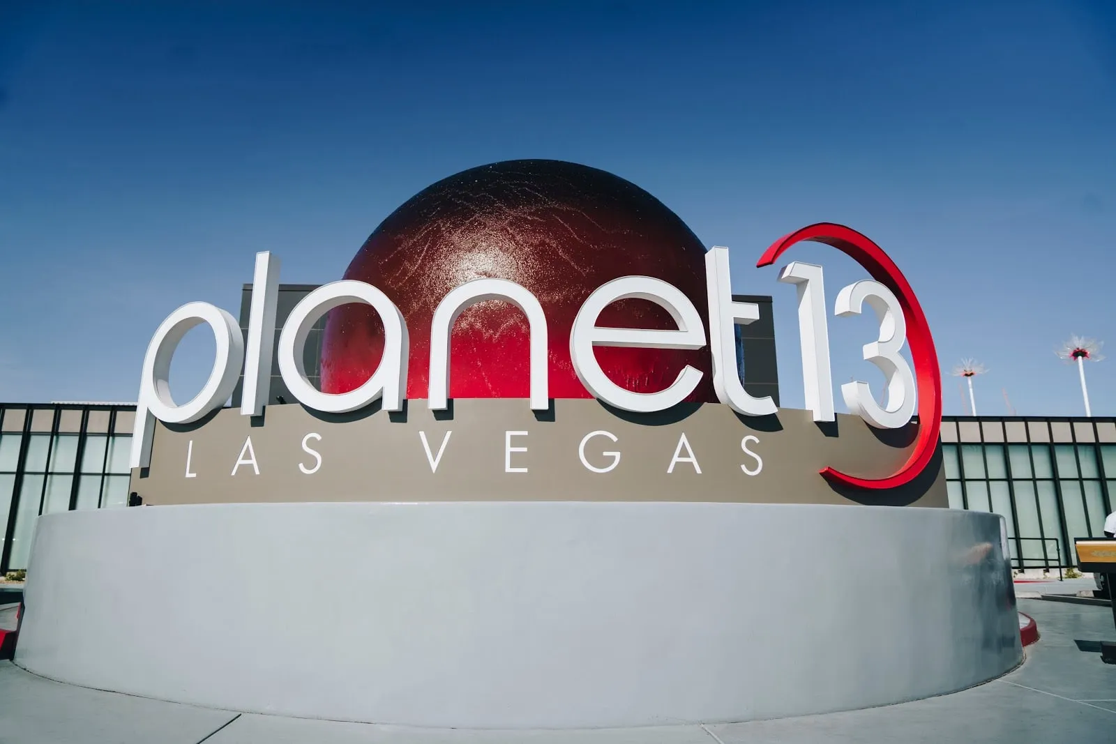 The Planet 13 Las Vegas sign and its red sphere under a blue sky