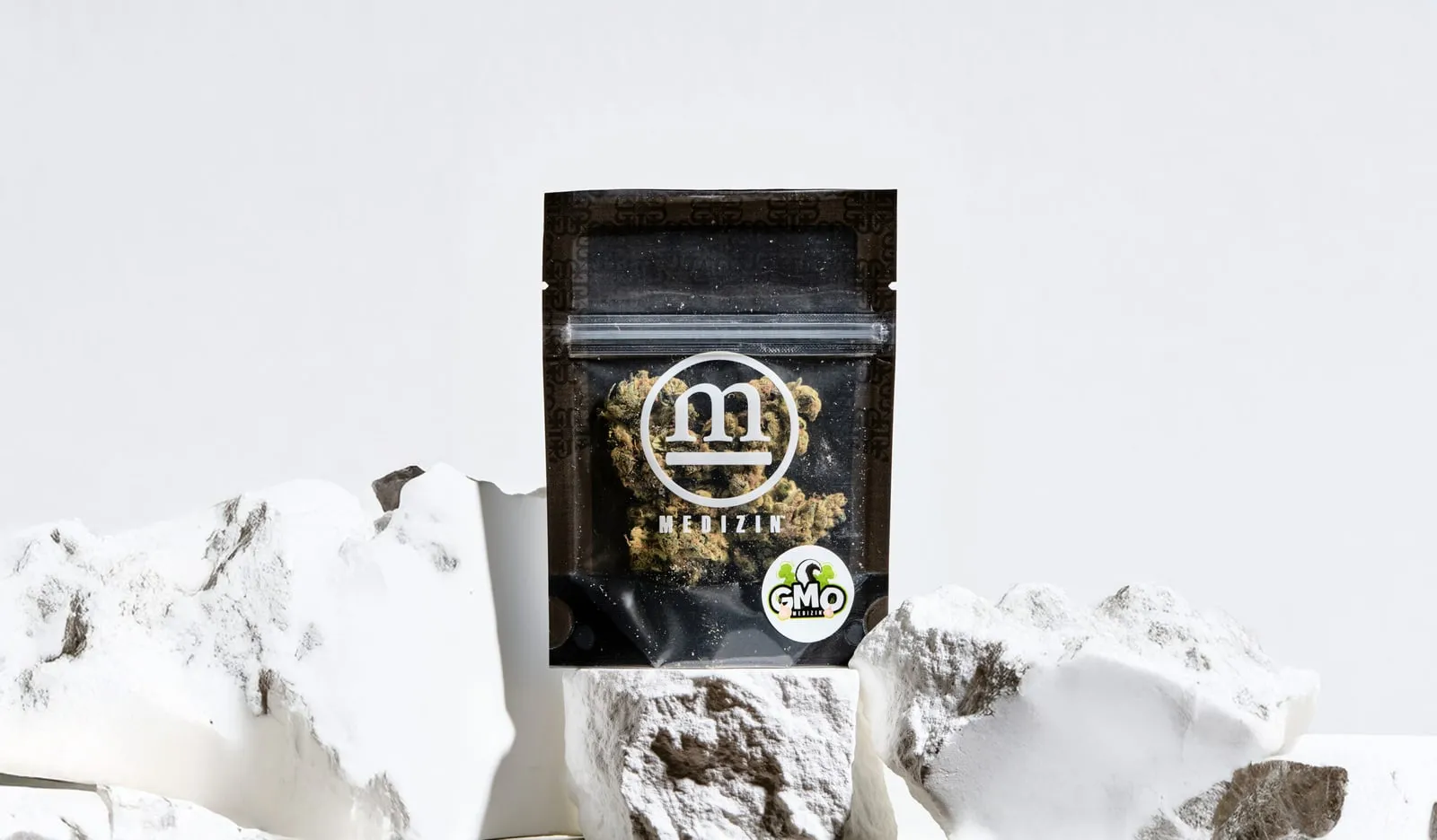 A bag of Medizin GMO flower on white stone