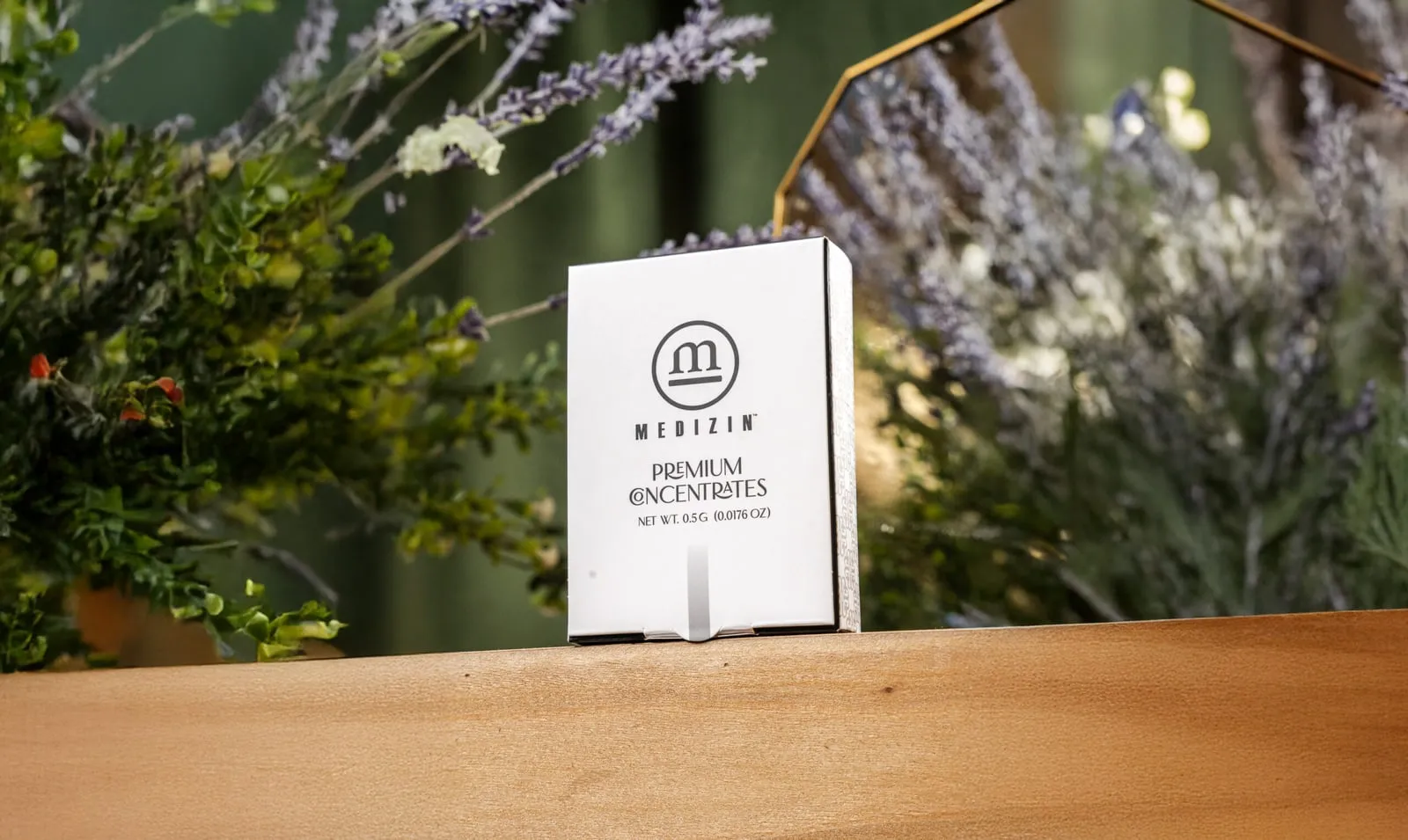 A box of Medizin premium concentrates on a wooden ledge among lavender