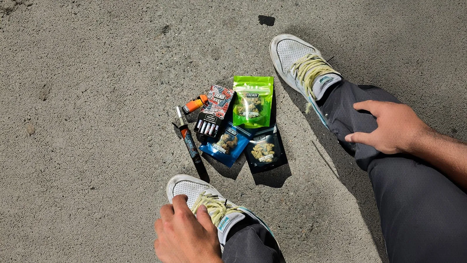 A skater sitting on concrete beside TRENDI products